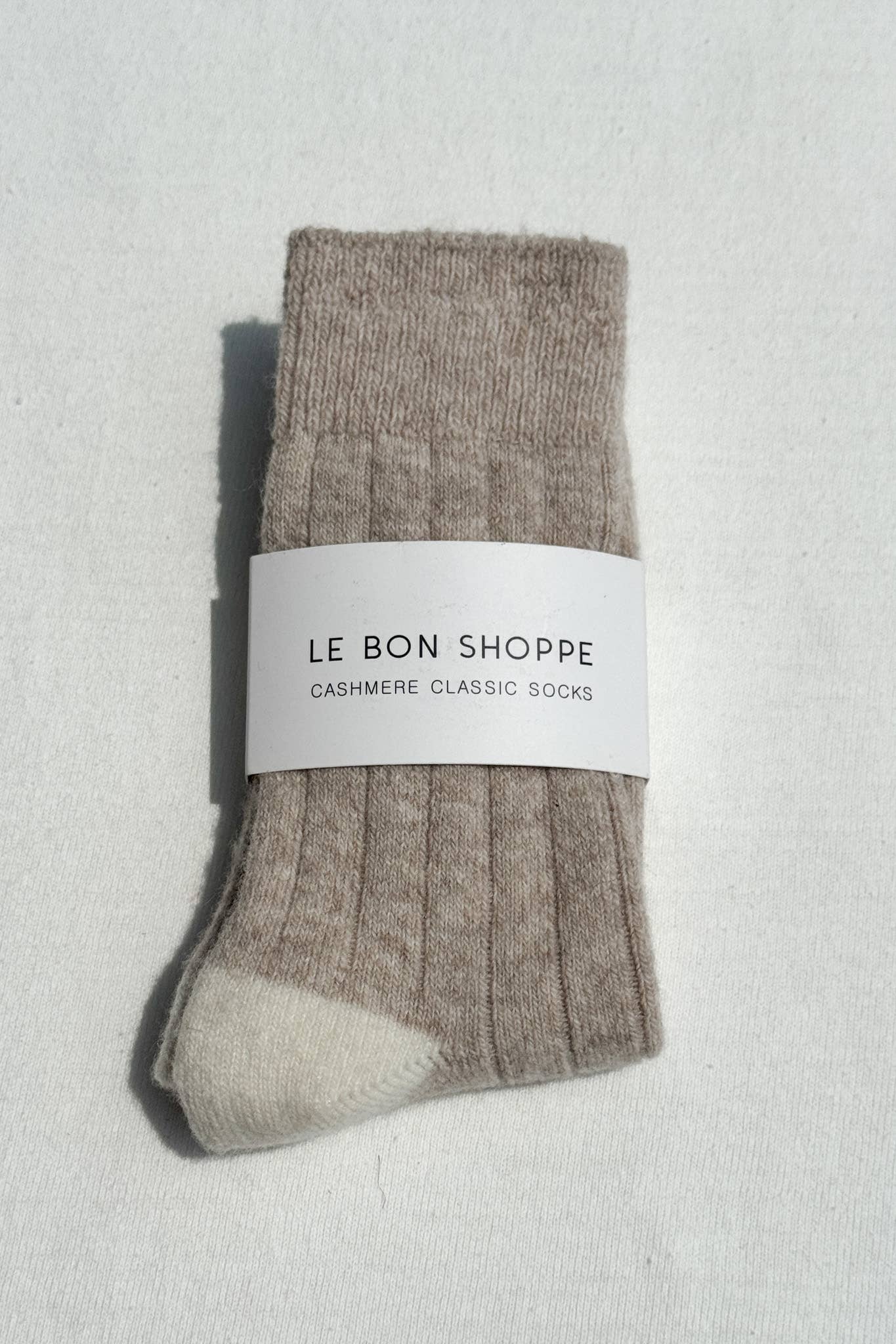Pair of brown cashmere socks with a 'Le Bon Shoppe' label on a light gray background