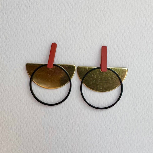 Pair of gold cat-shaped hair ties with red bands on a white background