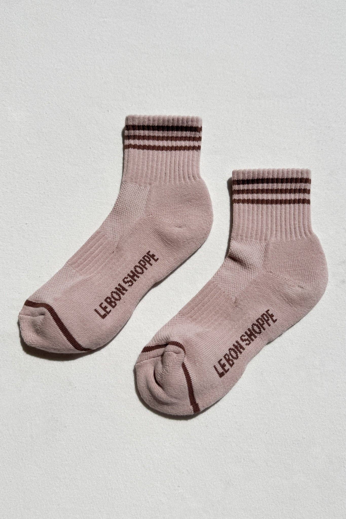 Pair of pink socks with brown stripes and 'LEBON SHOPPE' branding on a light gray background
