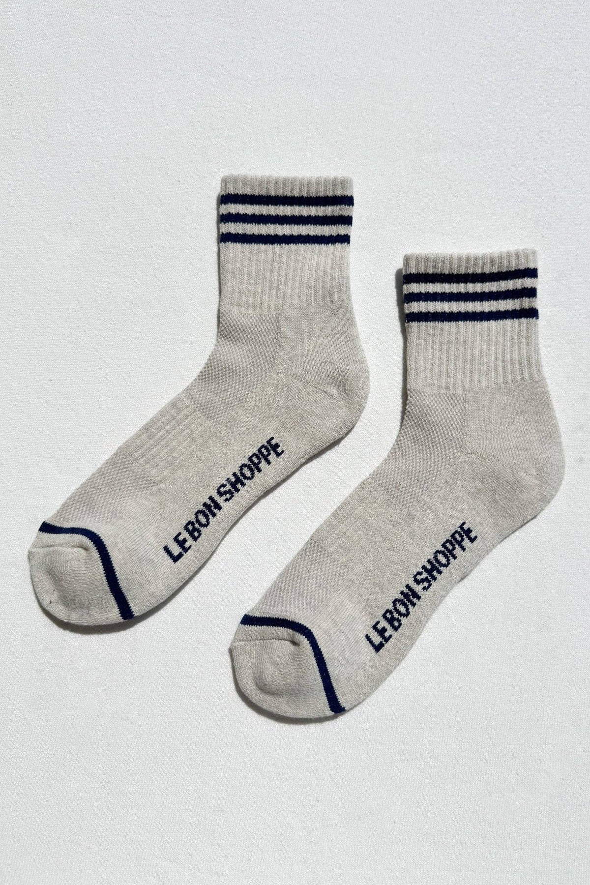 Gray socks with blue stripes and 'LE BON SHOPPE' branding on a white background
