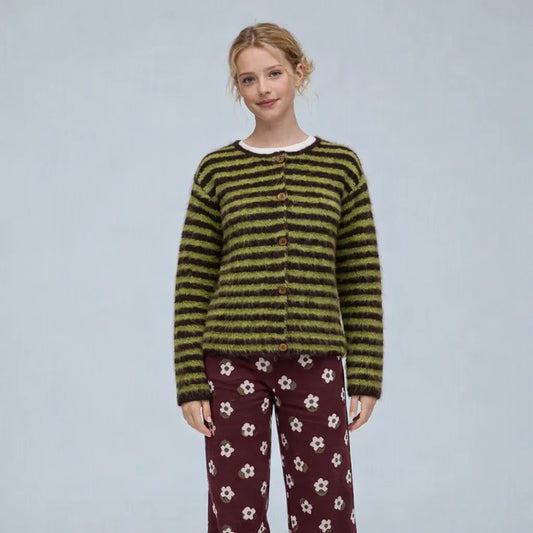 a model wearing a green and brown stripe cardigan with burgundy and white floral trousers on a grey background