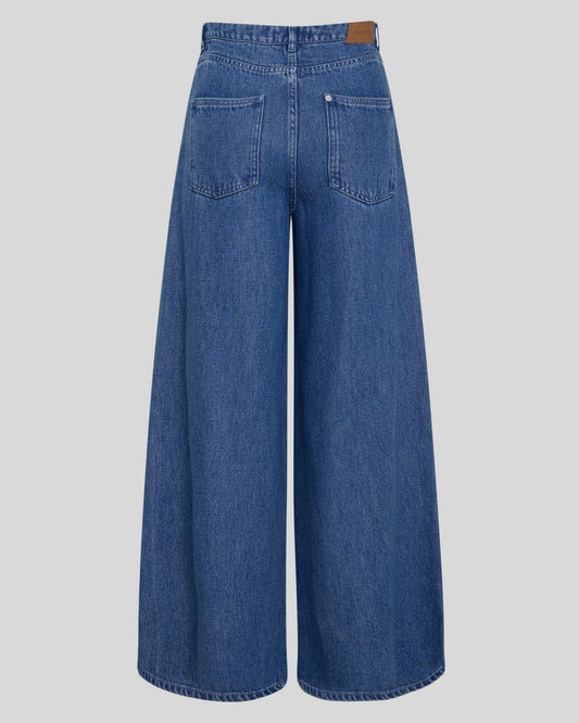 Blue wide-leg denim jeans shown from the back, featuring a high waist, back pockets, and a brown leather patch at the waistband, set against a solid light gray background.