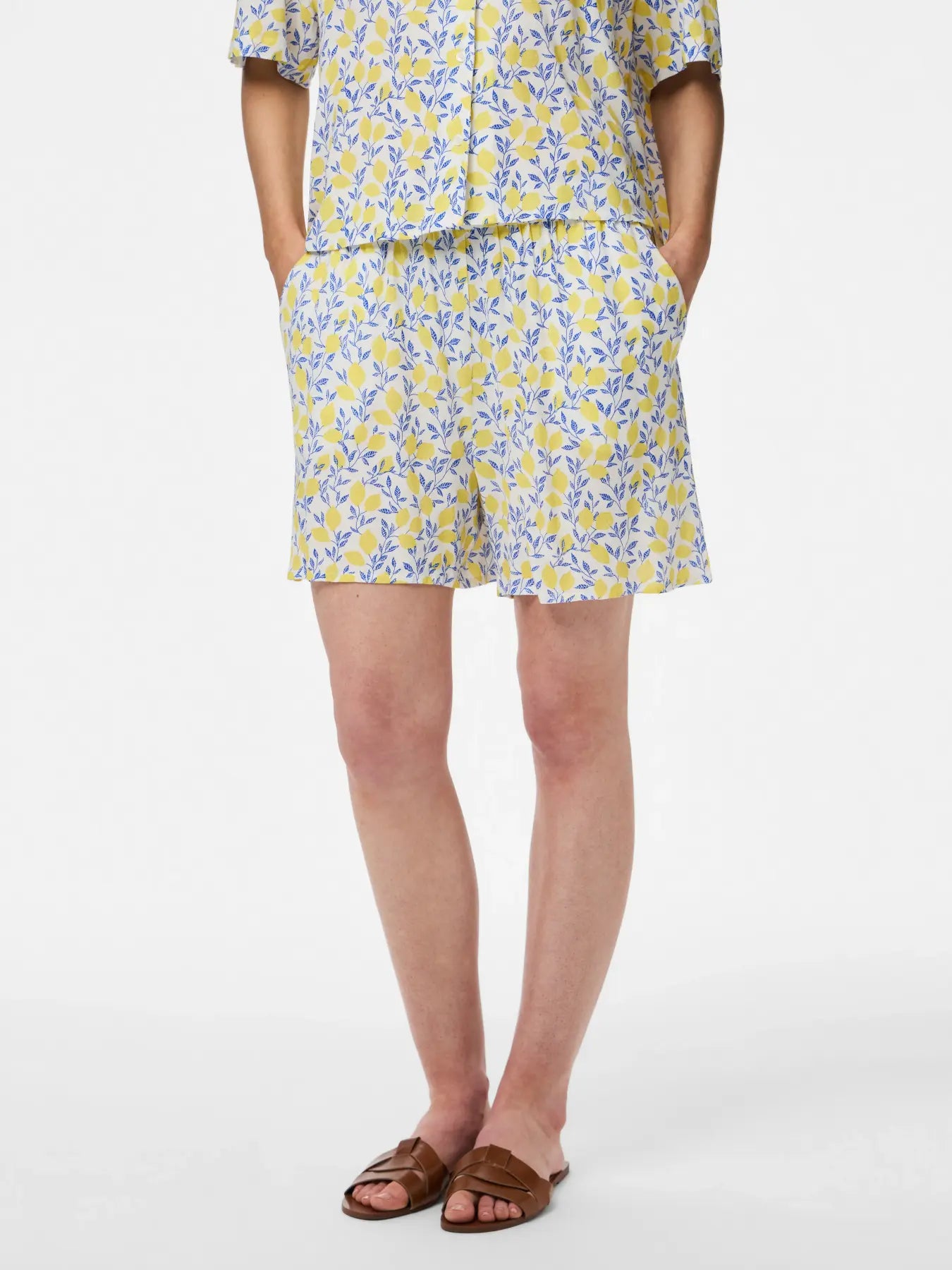 Person wearing a yellow and blue floral dress on a white background