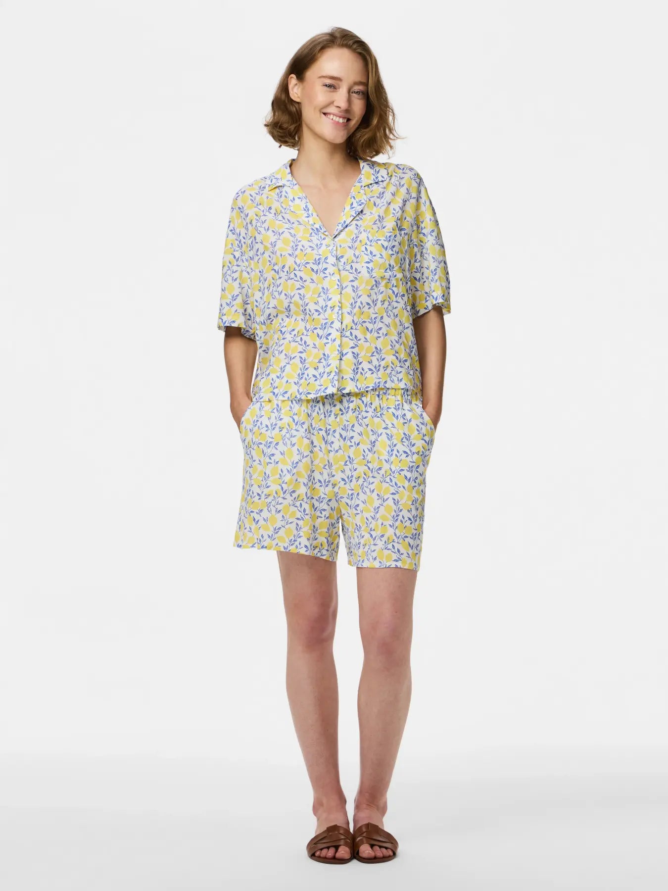 Woman wearing a yellow and blue floral outfit on a white background