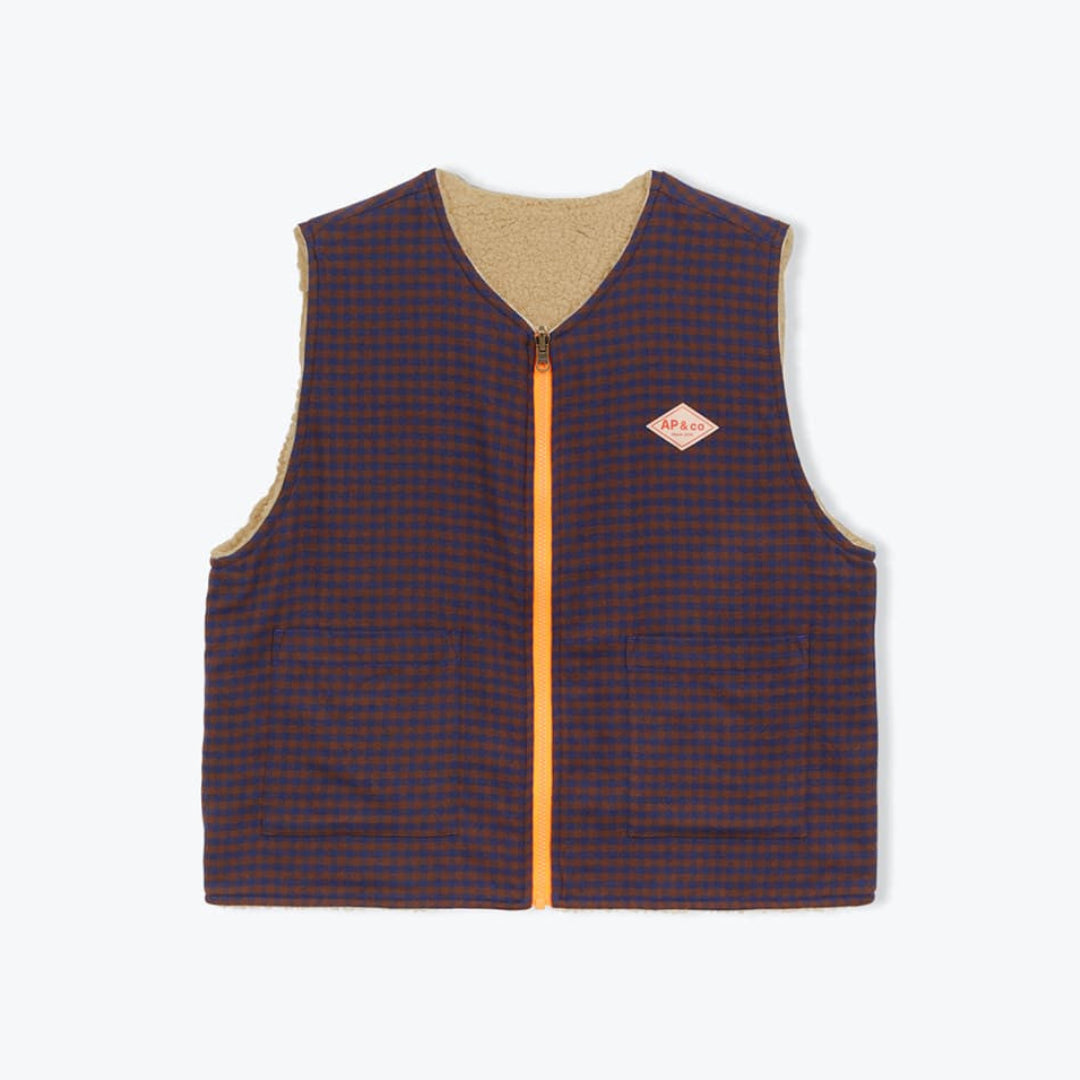 A sleeveless quilted vest with a dark navy and red checkered pattern, a tan interior lining, and a bright orange zipper. A small diamond-shaped orange logo patch is visible on the left chest.