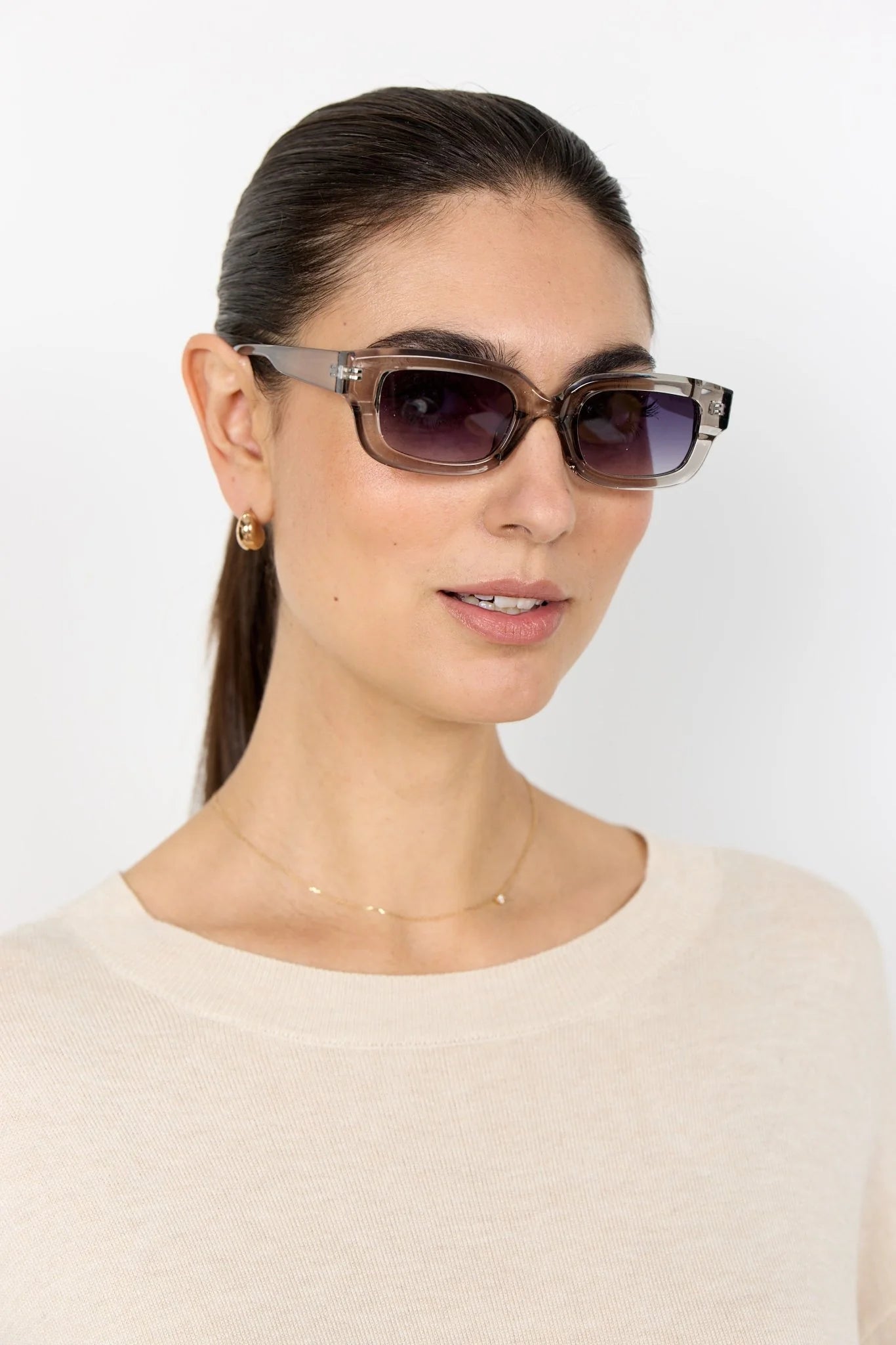 Woman wearing sunglasses with a plain background