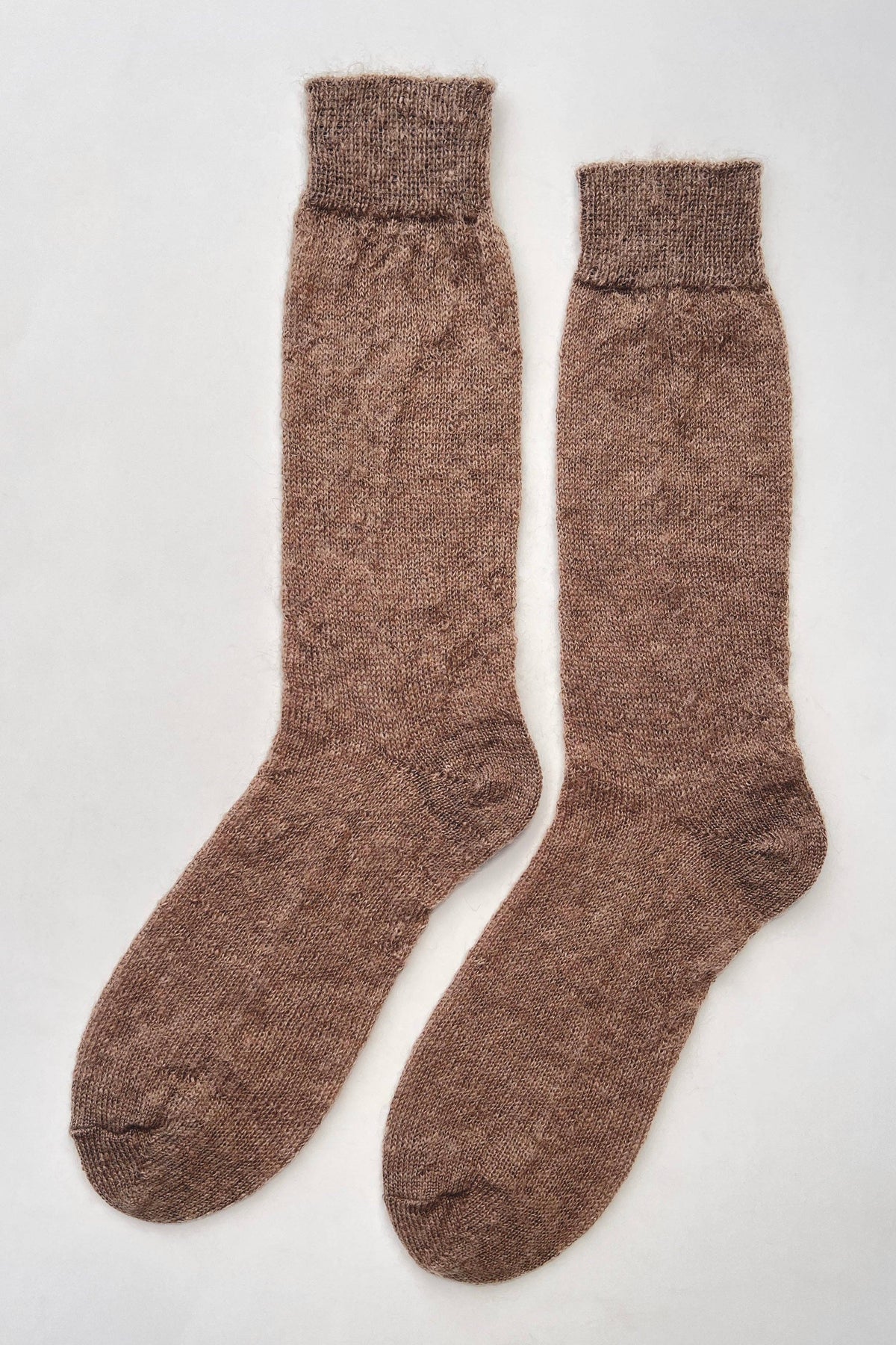 A pair of brown ribbed-knit crew socks laid flat on a light gray background.