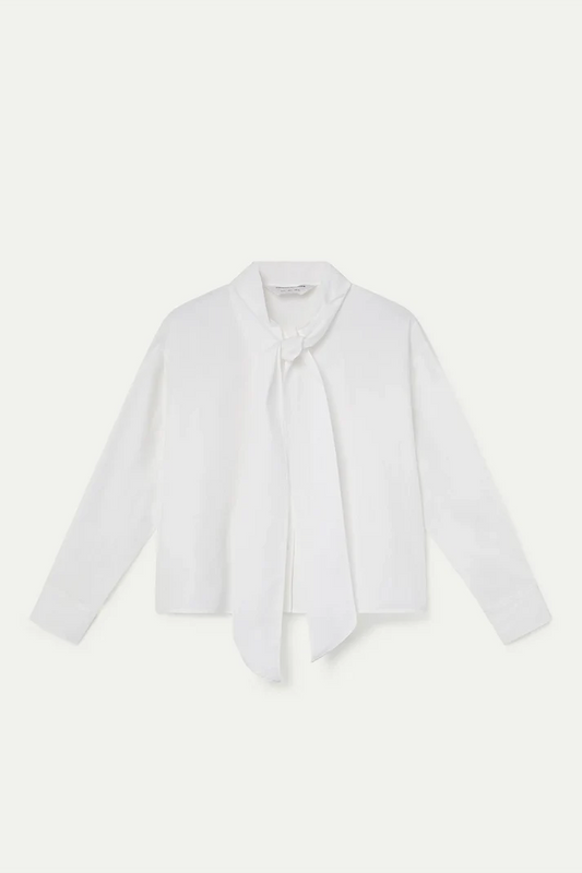 A white long-sleeve blouse with a wide collar and a self-tie neck scarf, laid flat against a light off-white background.