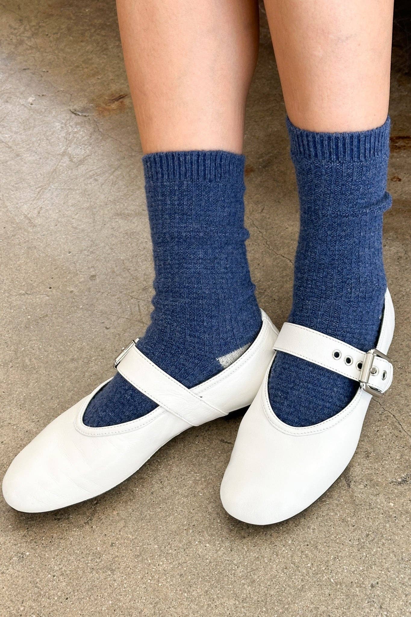 White shoes with blue socks on a neutral background