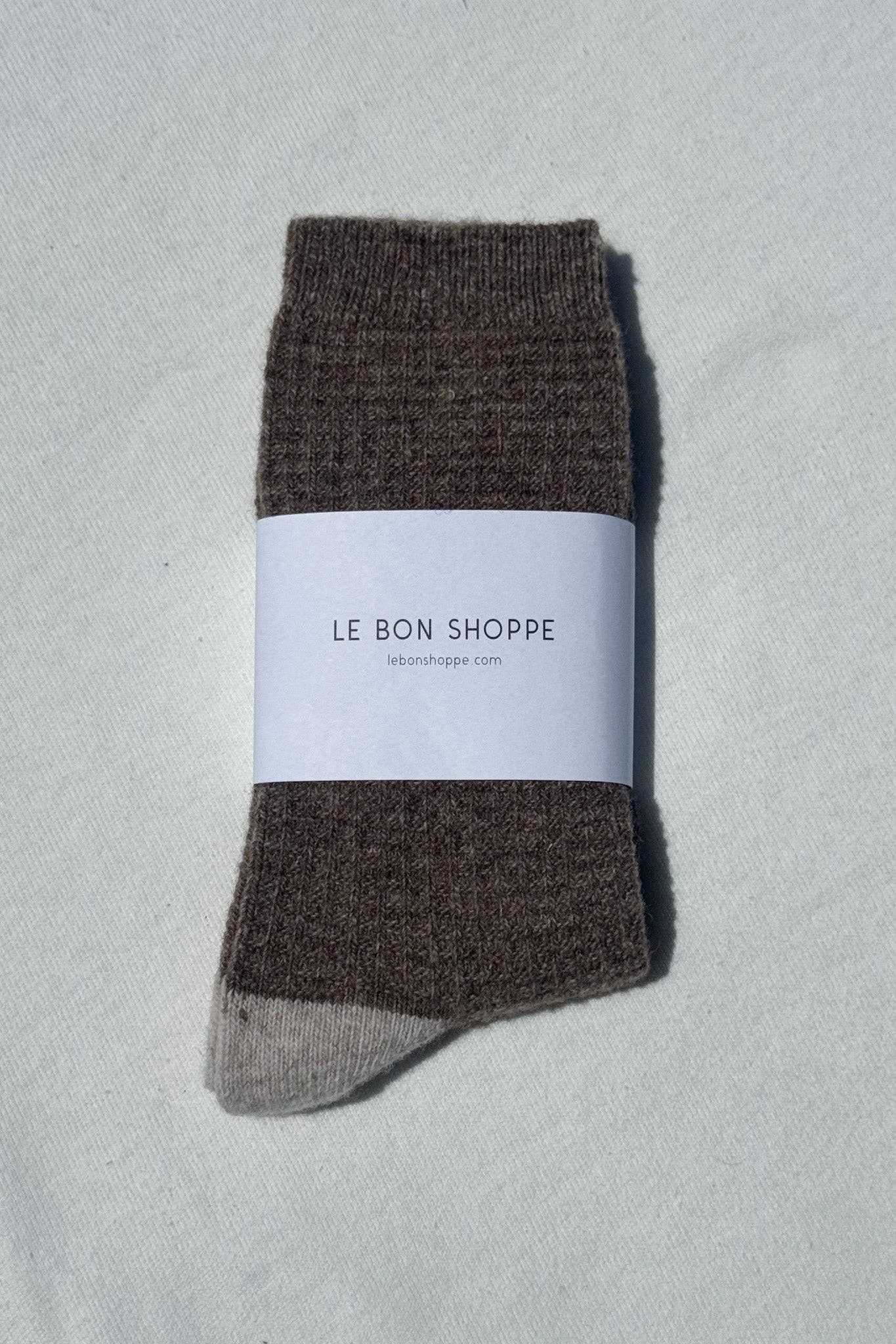 Brown sock with a white label on a light gray background