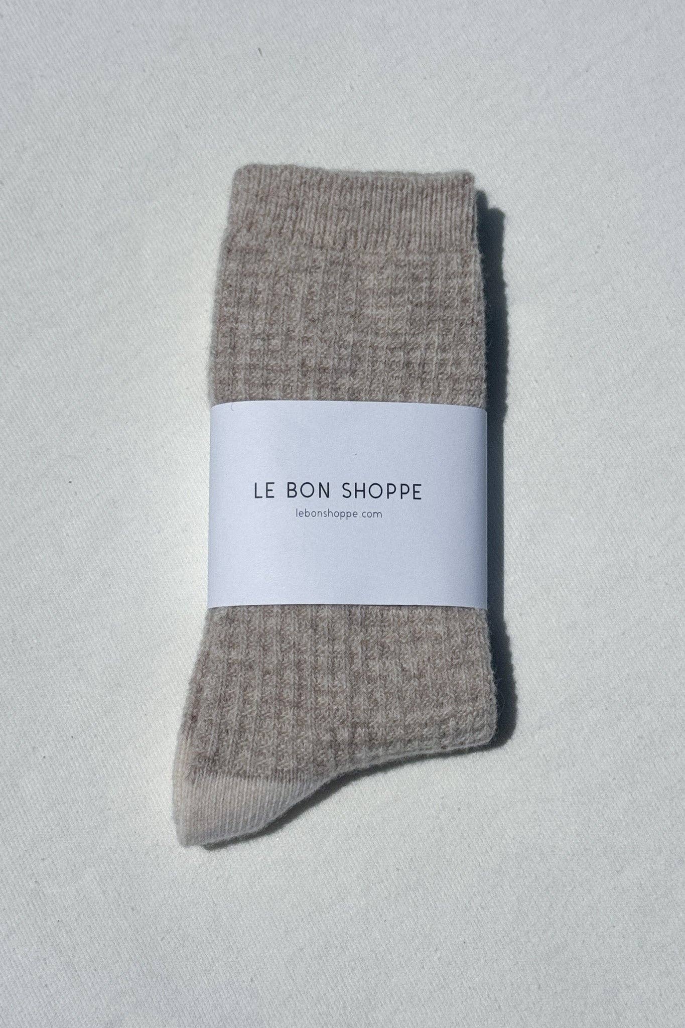 Pair of gray socks with a white label on a light gray background